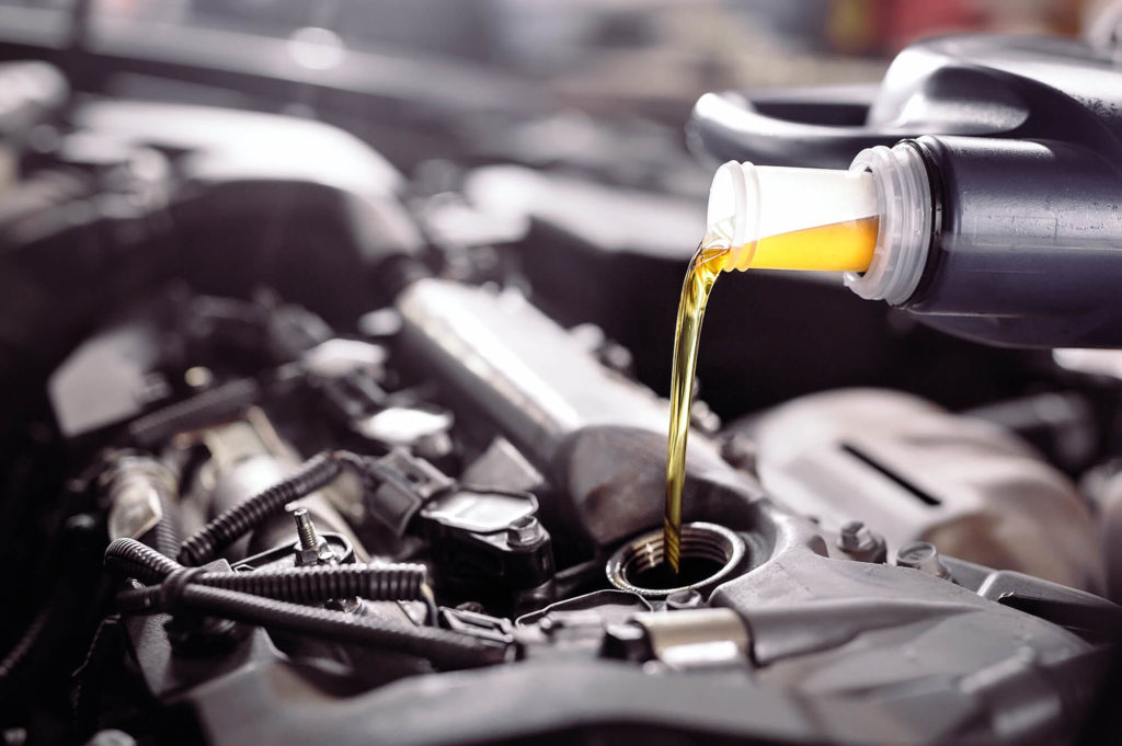 Motor oil pouring to car engine.